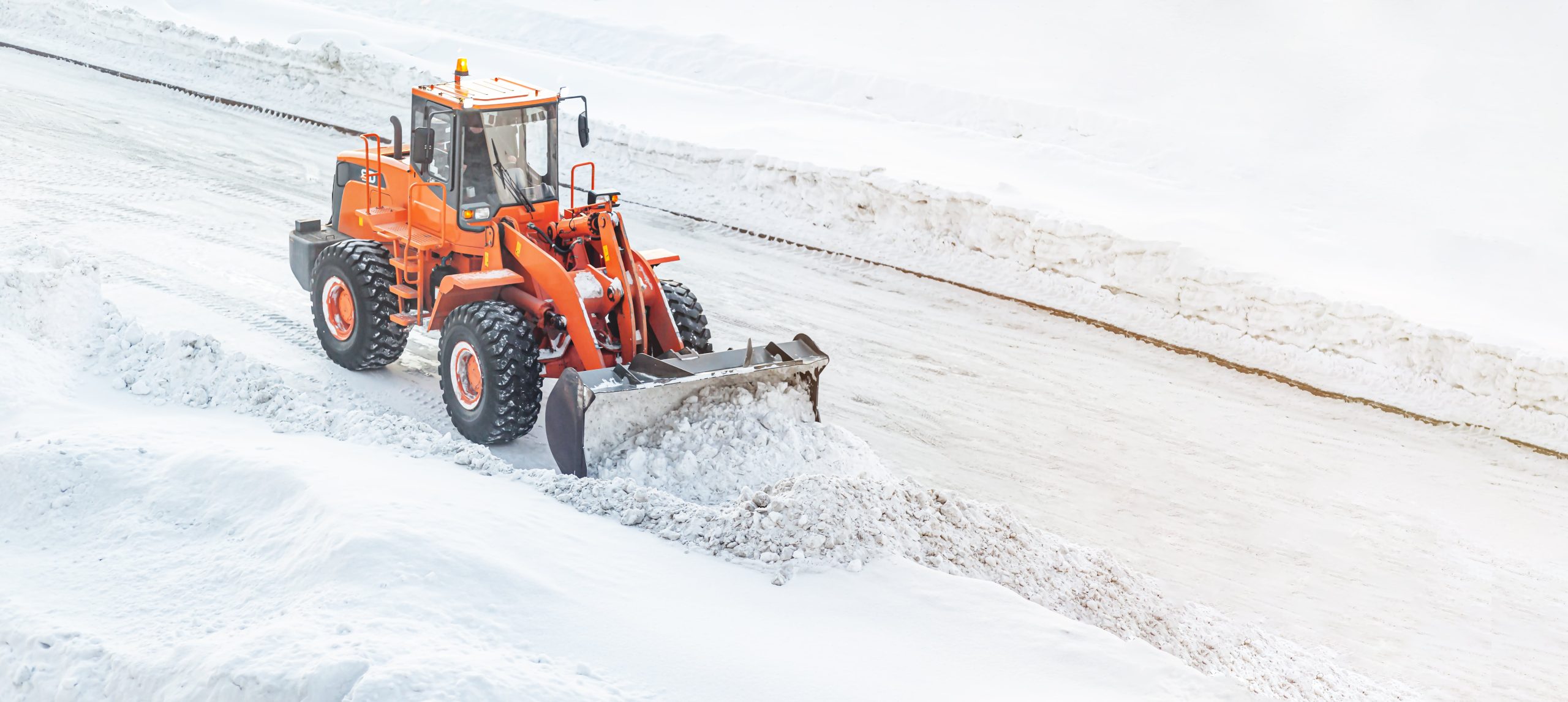 big-orange-tractor-removes-snow-from-the-road-and-2025-03-06-13-40-01-utc-min